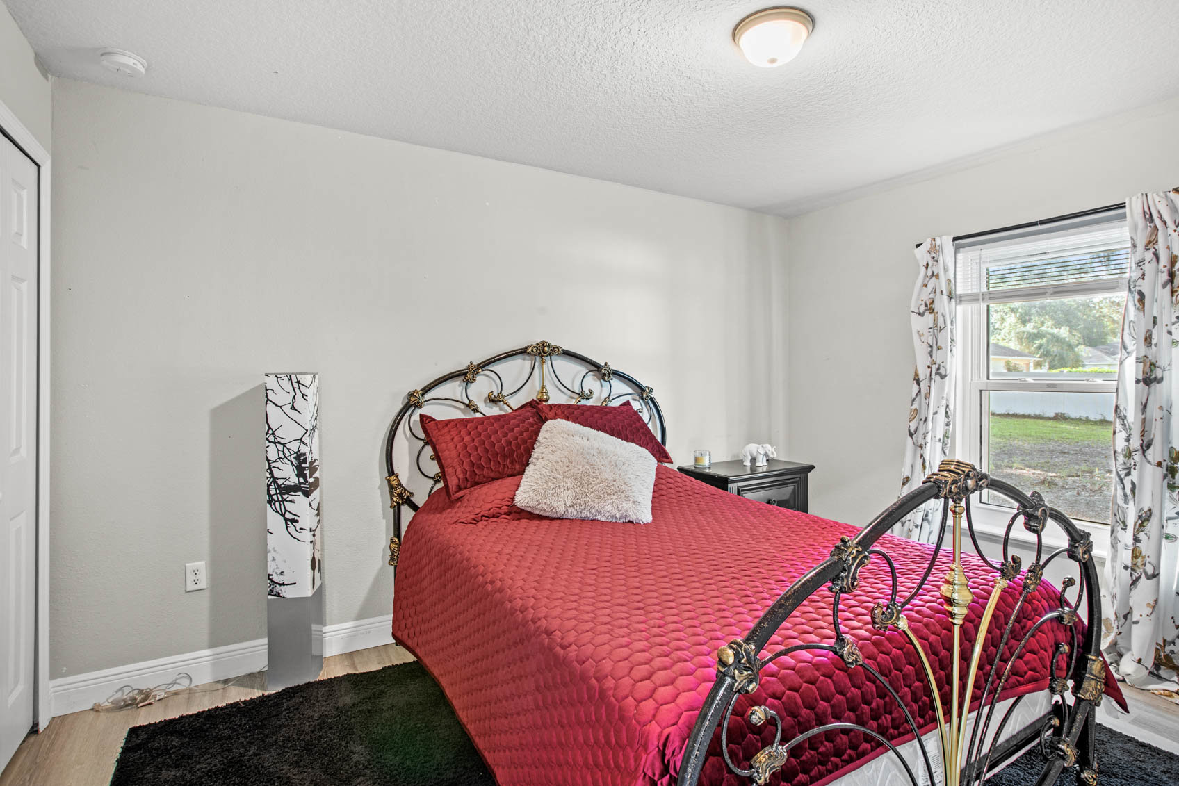 bedroom with red comforter and metal bed frame